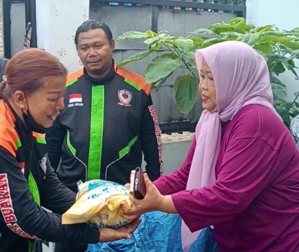 Pemimpin Redaksi Media Sudut Pandang, Umi Sjarifah, menyerahkan paket beras Jumat Berkah kepada pengemudi ojek online komunitas Sobat Buaran II di Klender, Duren Sawit, Jakarta Timur, Jumat (16/1/2026).